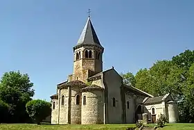 Église de Biozat. On distingue à droite la chapelle funéraire des Hutteau d'Origny et, devant celle-ci, la borne milliaire romaine ainsi qu'un bloc, dit « pierre celtique ».