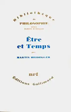 Couverture d'un livre. « Bibliothèque de philosophie - illisible - Être et Temps - Martin Heidegger - NRF - édition Gallimard ». Sur un fond blanc, au centre de deux zones écrites arc de cercle ocre se détache le titre en bleu