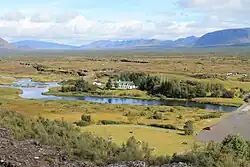 Vue de la partie septentrionale des Þingvellir depuis le rebord sud-ouest du horst avec au premier plan la Öxará, dominés à droite par la Hrafnabjörg ; à gauche au dernier plan se trouve le Skjaldbreiður.