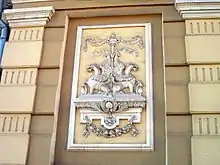 Écusson Héraldique de Lev figurant sur sa maison : Griffon modifié avec corps de lion évoquant son prénom et tête de dragon évoquant sa ténacité.