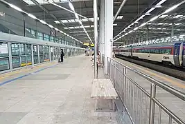 à droite les voies et quais de la gare, à gauche un quai du métro.