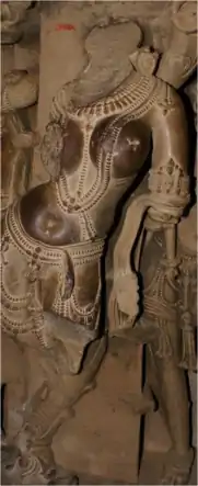 Statue sans tête, la tête est remplacée par la figure 8 représentant un champignon anthéogène. Temple de Jagdambi , Khajuraho, Inde