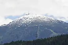 Vue d'une montagne en partie enneigée.