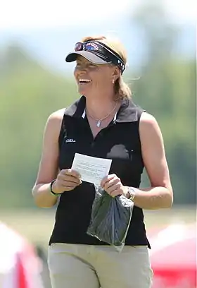 Liselotte Neuman, debout, tenant un papier dans les main.