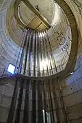 L'intérieur d'un château en béton avec un escalier en colimaçon et une dizaine de conduites métalliques.