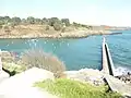 L'entrée de la ria de Brigneau vue depuis la rive ouest ; au premier plan, la jetée protégeant l'entrée de la ria.