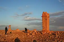 Photographie en couleurs de tours en ruines dans un désert.