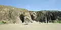 Les falaises et les grottes au nord de la plage de Ty Anquer vues de la plage à marée basse.