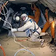 Photographie en couleur de Scott en combinaison et en apesanteur.