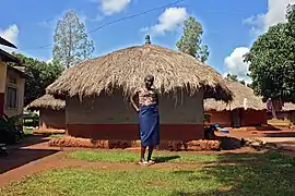 Une femme devant sa maison.
