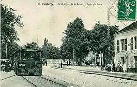 Le tramway à Nanterre, en direction de Saint-Germain-en-Laye, tracté par une locomotive à vapeurBlanc-Misseron « bicabine ».