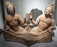 Deux rois nāga émergeant à mi-corps d'un bassin, de part et d'autre de la tige d'un lotus. Vallée du Ghorband. Monastère de Fondukistan, niche D. VIIe siècle. Terre séchée. Musée Guimet, Paris.
