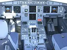 Photo rapprochée prise au centre d'un poste de pilotage, constitué de multiples cadrans, boutons et leviers.