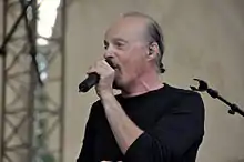 Portrait photographie d'Alan Stivell tenant un micro