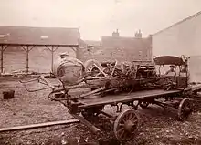 Photo des restes d'une voiture accidentée posée sur un plateau roulant.