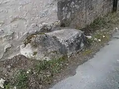 Vue d'un massif de pierres recouvert de béton moderne au bord d'une rue.