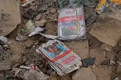 Amoncellement de détritus et de gravas, dont parmi ceux-ci figure une cartouche des jeux vidéo E.T. et Centipede très détériorées (de couleur grise, rouge et bleue).