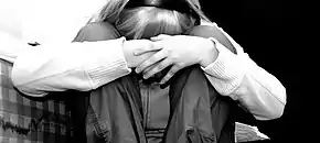 Photo noir et blanc d'une fille avec la tête entre les genoux