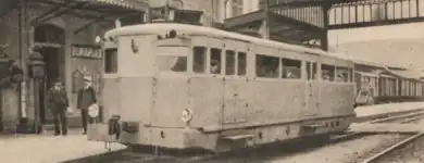 Photographie en sépia d'un petit autorail en gare.