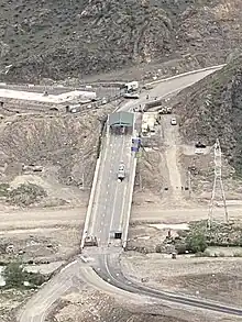 Photographie d'un pont routier bloqué par une barrière gardée par des militaires.