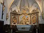 Le chœur de l'église avec l'autel, le tabernacle et le retable.