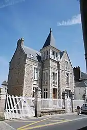 Vue d’une maison en pierre, avec clocheton.