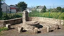 Photographie d'une fontaine maçonnée.