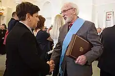Photographie de Beata Szydło en train de féliciter Franciszek Pieczka.