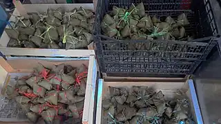 Zongzi vendus dans le quartier chinois de Belleville, à Paris, à la veille du Festival de Dunwu. Les couleurs des ficelles distinguent les parfums.