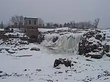 Photographie des chutes de Sioux Falls, gelées en hiver.