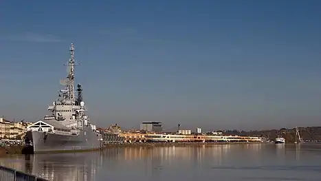 Photographie de nuit d'un bateau en acier accosté sur les quais illuminés.