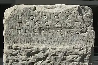 Borne  marquant la limite de la Voie Sacrée à Athènes. La fin de l'inscription d'origine, modifiée au Ve siècle av. J.-C., se lit ΗΟΡΟΣ ΤΕΣ ΟΔΟ ΤΕΣ ΕΛΕΥΣΙΝΑΔΣΙ (« Borne de la route d'Éleusis »). Vers 520 av. J.-C.. Trouvée dans le lit de l'Éridanos. Musée archéologique du Céramique.