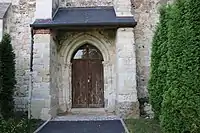 Portail en plein cintre de l'église protégé par un auvent.