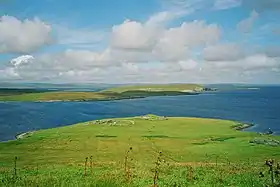 Paysage de Bressay : les ruines de la chapelle Sainte-Marie, le Voe of Cullingsburgh, la péninsule d'Aith Ness et Mainland au dernier plan.
