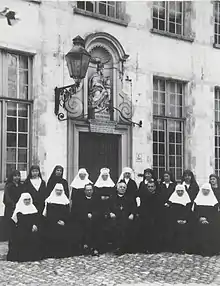 Réunion en 1926 des béguines de Bruges et des Filles de saint Benoît de Nîmes, rassemblées autour de trois prélats (Don Gaspar Lefebvre à gauche, Rodolphe Hoornaert à droite, et un prélat britannique au centre)