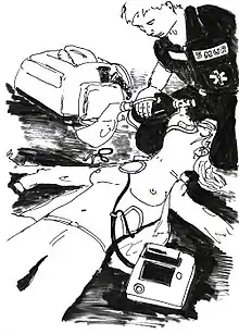 Vue de l'opérateur du défibrillateur : Un secouriste est à genoux à la tête de la victime et lui administre de l'oxygène. Si la tête de la victime est entre ses genoux, elle n'est pas serrée. Les électrodes de défibrillation sont collées.