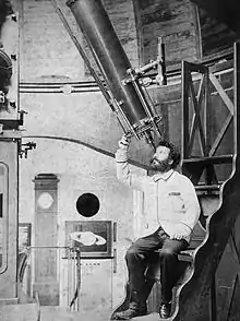 photographie de Camille Flammarion observant dans un téléscope