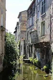 Photographie du canal des usines entre deux immeubles.