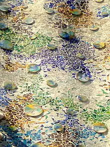 Détail de la façade couverte de bris de céramiques colorées.