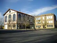photo couleur d'un bâtiment à structure métallique et murs ouverts de grandes verrières.
