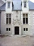 Photographie en couleurs d'un mur percé d'une porte dont les entourages sont très ouvragés.