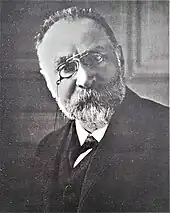 Portrait photographie d'un homme âgé portant des lunettes.