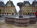 Fontaine actuelle avec son soubassement en pierre de Jaumont (calcaire Bajocien), ses vasques et son piédestal en marbre rouge belge.