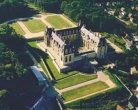 Sur cette photographie aérienne du château d'Écouen on perçoit bien les éléments médiévaux : le plan carré, la position dominante et stratégique, les douves…