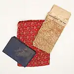 Photographie de trois objets rectangulaires de couleurs et de dimensions différentes disposés en éventail.