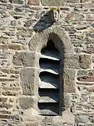 Corbeau à tête grotesque sur fenêtre en arc bouté face sud.