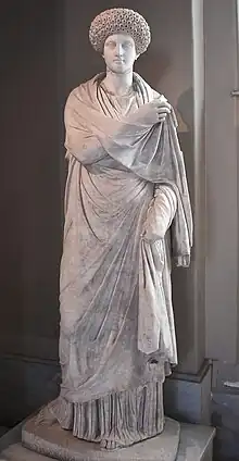 statue féminine en marbre : elle est en toge, avec une coiffure élaborée