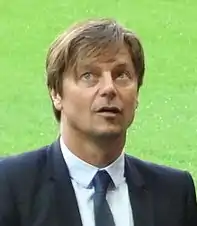 Épaules et visage d'un homme de face. Arrière-plan neutre.