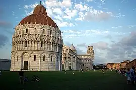 Photographie montrant une cathédrale (dôme) et la tour penchée de Pise à l'arrière-plan.