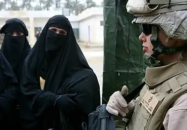 Femmes portant un niqab et marine américain gardant l'entrée d'une clinique médicale à Saqlawiyah en Irak (2008)